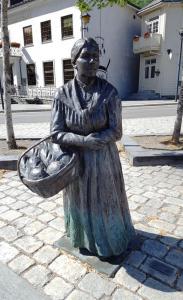 Bronze statue of Simons-Margreta (1872-1949) with a basket of food 